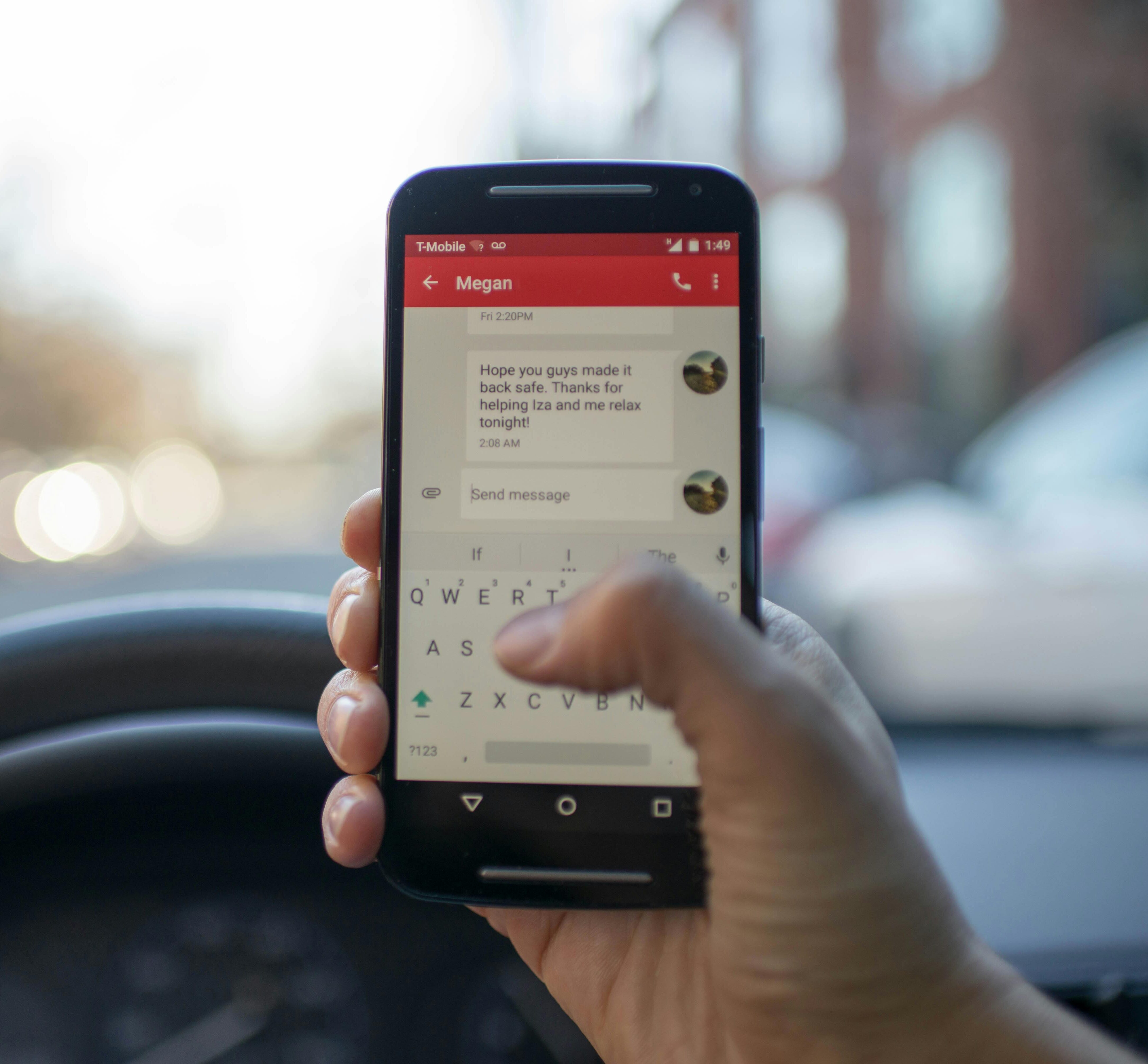 Close-up of a person texting on a smartphone while driving a vehicle, highlighting distracted driving.